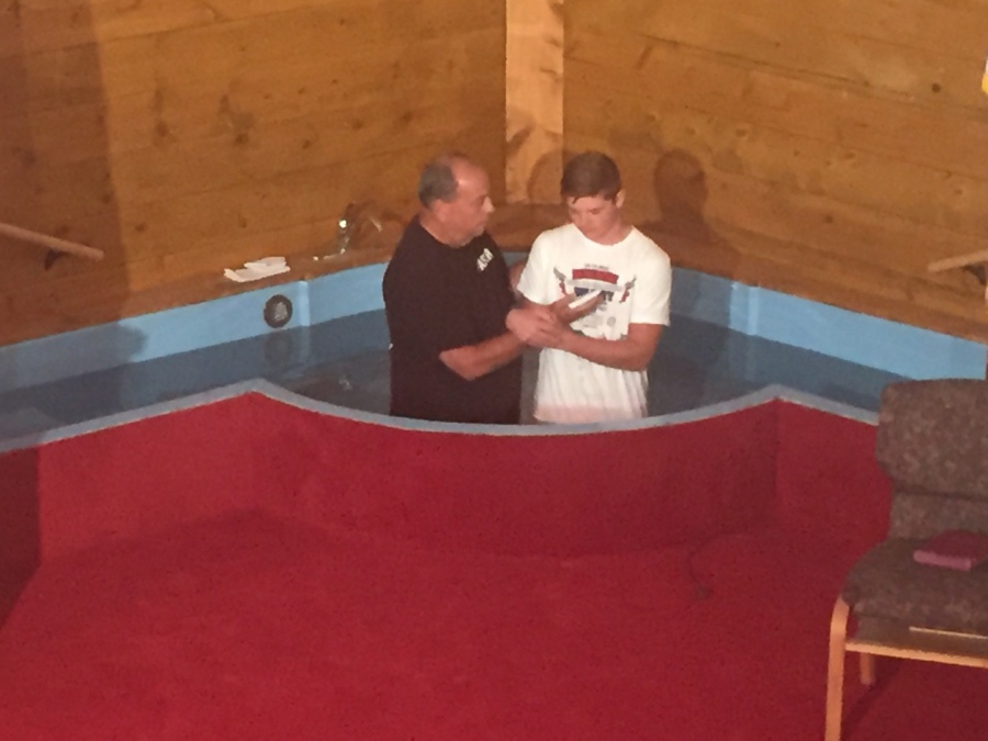 Young man getting baptized